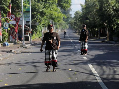 Balinese Hindu guards, known as Pecalang, patrol an empty road near Ngurah Rai International Airport on Nyepi, the Balinese day of silence, in Kuta, Bali, Indonesia March 17, 2018.  REUTERS/Johannes P. Christo