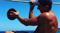Gokil, Marcus Bondi melakukan chin up dengan tangan kanan, sementara tangan kirinya memegang beban tambahan. (Foto: Instagram/MarcusBondiBeach) 