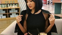 Dengan mengenakan baju berwarna hitam, Mikha tampak sedang ingin menikmati segelas es cappuccino. Slurrrp! Foto: Instagram @miktambayong