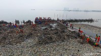 Tampak petugas membersihkan sampah menggunakan tangan kosong serta cangkul.