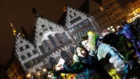 Pengunjung berselfie di depang gedung yang bermandikan cahaya.  REUTERS/Kai Pfaffenbach.