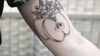  Wanita bernama Sarah ini mentato lengan tangan bagian atasnya dengan gambar buah apel. Sengaja dibuat tidak berwana agar lebih terkesan artistik. Foto: Instagram @geehawkestattoo