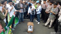 Massa lalu melepas burung dari kandang. Sebagai gantinya, foto Anies diletakkan di sangkar