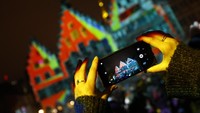 Tak sedikit dari warga dan pengunjung yang mengabadikan gedung-gedung yang terlihat indah saat Festival Luminale 2018. REUTERS/Kai Pfaffenbach.