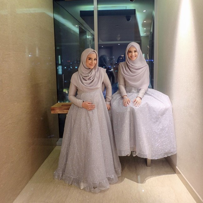 Zaskia Sungkar dan Shireen Sungkar kompak memakai busana syari saat pernikahan adik bungsunya. Mereka tampil anggun dan simple dengan busana bernuansa star dust yang sedang tren. Mereka memakai hijab segi empat yang dipakai menjuntai menutupi dada. Foto: Instagram/Shireensungkar