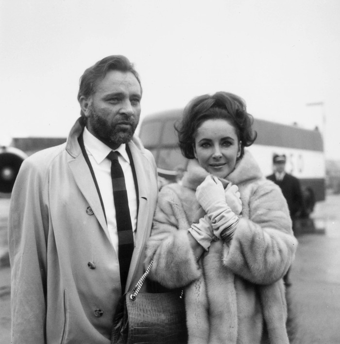 artis kawin-cerai 1st February 1966:  Welsh stage and film actor Richard Burton (1925 - 1984) with his wife, actress Elizabeth Taylor at London Airport.  (Photo by George Stroud/Express/Getty Images)