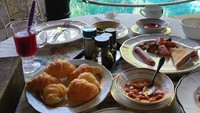 Dengan memandang kolam renang yang biru, penyanyi asal Malaysia ini terlihat sedang menikmati menu sarapan a la Barat. Selain roti, ada juga croissant dan jus buah yang menyehatkan. Foto: Instagram @ctdk