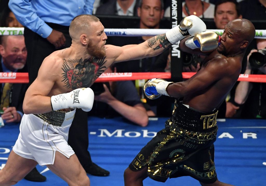 LAS VEGAS, NV - AUGUST 26:  Floyd Mayweather Jr. (R) avoids a punch from Conor McGregor in the first round of their super welterweight boxing match at T-Mobile Arena on August 26, 2017 in Las Vegas, Nevada. Mayweather won by 10th-round TKO.  (Photo by Ethan Miller/Getty Images)