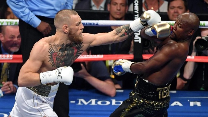 LAS VEGAS, NV - AUGUST 26:  Floyd Mayweather Jr. (R) avoids a punch from Conor McGregor in the first round of their super welterweight boxing match at T-Mobile Arena on August 26, 2017 in Las Vegas, Nevada. Mayweather won by 10th-round TKO.  (Photo by Ethan Miller/Getty Images)