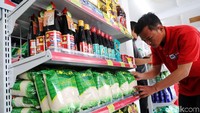 Pekerja merapikan produk-produk di 212 Mart.