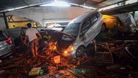 Warga mengamati kendaraan yang terseret banjir bandang di Cicaheum, Bandung, Jawa Barat, Selasa (20/3). 