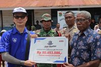 Eddy Ang memberikan donasi kepada Kepala Sekolah SD Inpres, Rasyid Longsoh (Foto: Dok Yamaha)