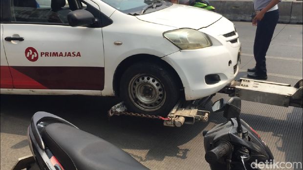 Sopir taksi hanya bisa pasrah saat mobilnya diderek petugas