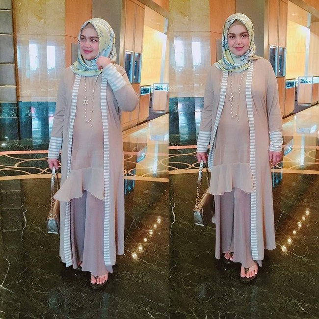 Tak hanya dress, pilihan Siti Nurhaliza juga jatuh pada outerwear panjang dan celana longgar. Penampilan serba loose dan tertutup ini membuatnya tampil kasual dan tetap chic.  Foto: Instagram/ctdk