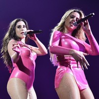 Tampil maksimal di panggung dengan bodysuit kulit berwarna pink cerah. Foto: Getty Images