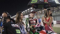 Aleix Espargaro bersiap memulai balapan di atas motor Aprilia Racing Team Gresini. Di sebelahnya, setia menemani seorang umbrella girl (Photo by Mirco Lazzari gp/Getty Images)