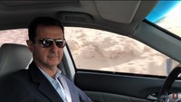Assad berbicara dengan kata-kata tidak formal ke arah kamera. Selama mengemudikan mobil, Assad terus berbicara memberikan komentar soal area-area yang dia lewati. Assad juga membahas soal operasi militer Suriah. Foto: Screenshot YouTube/PresidencySy