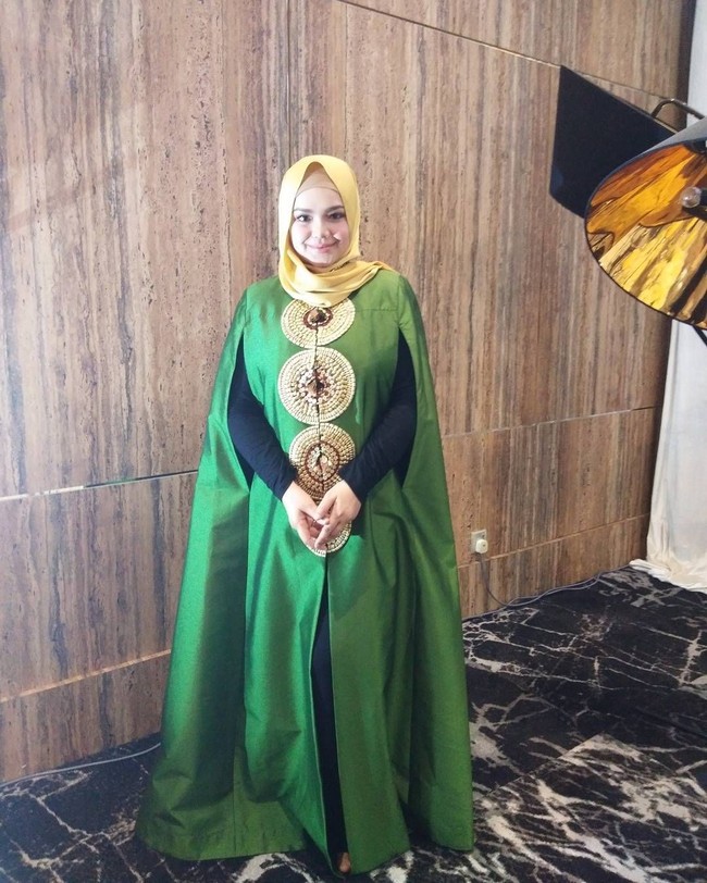 Siti Nurhaliza juga kerap tampil berbeda dengan outerwear berbentuk cape panjang. Memakai warna-warna terang seperti hijau seperti ini selalu cocok dengan kulitnya yang putih. Foto: Instagram/ctdk
