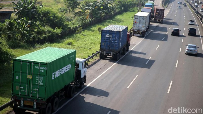 Puluhan truk kontainer parkir di bahu jalan tol JORR Bintara Jaya, Bekasi Barat, Selasa (20/3/2018). Mereka dilarang masuk tol sebelum jam 09.00 WIB.