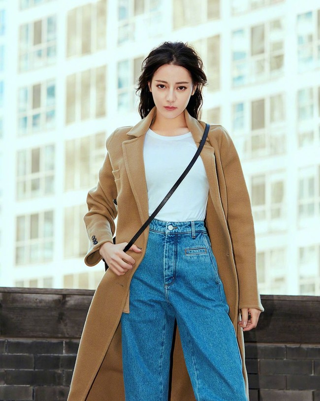 Penampilan kasual Dilraba yang mengenakan coat panjang nuansa khaki dan dipadukan dengan jeans. Foto: Instagram