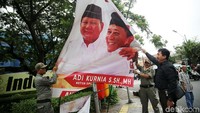 Petugas pengawas Pemilu menurunkan spanduk Partai Gerindra.