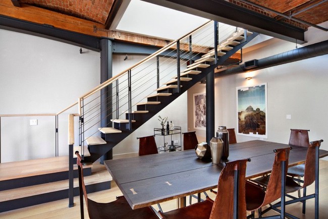 Interior penthouse bergaya industrial dengan banyaknya detail-detail unfinished pada langit-langit, dinding, lantai serta tangga. Foto: Dok. Stribling Marketing Associates