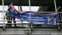 Satpol PP menurunkan spanduk Partai Demokrat.