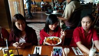 Sebelum makanan tersaji di meja, teman-temannya asyik selfie. Habis foto jangan lupa diposting ya! Foto: Devi S. Lestari / detikFood