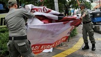 Satpol PP juga dikerahkan untuk menurunkan spanduk parpol.
