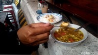 Pembatas jalan atau separator tersebut tak lazim digunakan untuk berjualan.