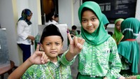 Dua siswa SD Al-Azhar 02, Pasar Minggu, Jakarta, saat memamerkan jari kelingking di depan kamera usai mengikuti simulasi pemungutan suara di Kantor KPU Pusat Jakarta, Kamis (22/3/2018).