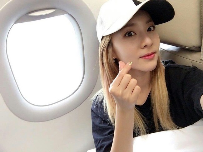 Sandara Park ketika di pesawat tak lupa berpose finger heart. Foto: Instagram