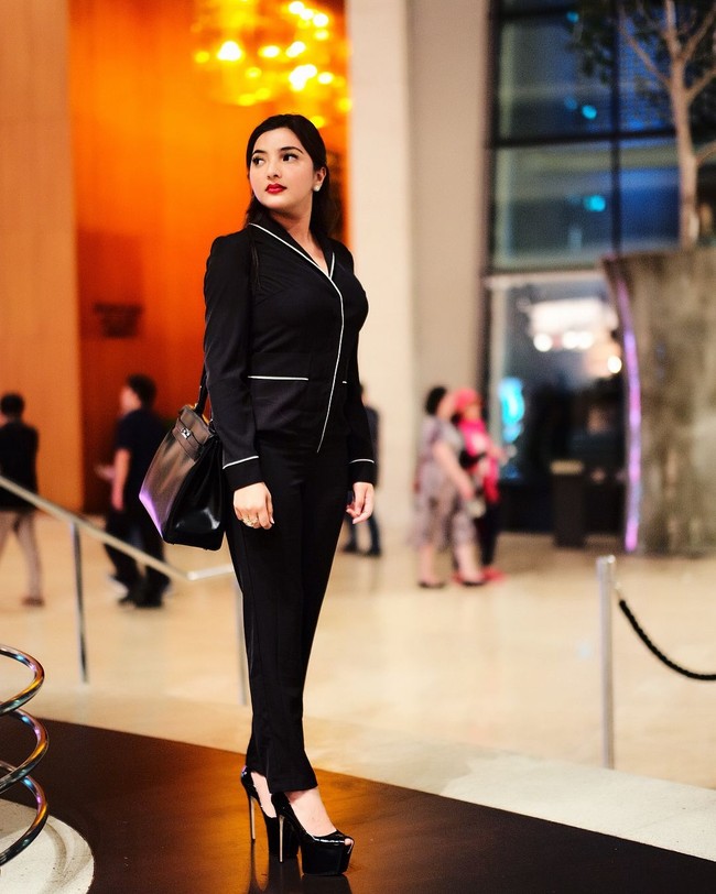 Tampil formal serba hitam saat berada di Hotel Marina Bay Sands, Ashanty yang kini sibuk mengelola restoran Dapur Asix melengkapi gayanya dengan tas Hermes Kelly seharga Rp 250 jutaan. Foto: Instagram