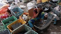 Pekerja memotong sampah menjadi kecil-kecil sebelum digiling.