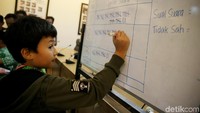 Seorang siswa mendapat tugas menghitung hasil surat suara.