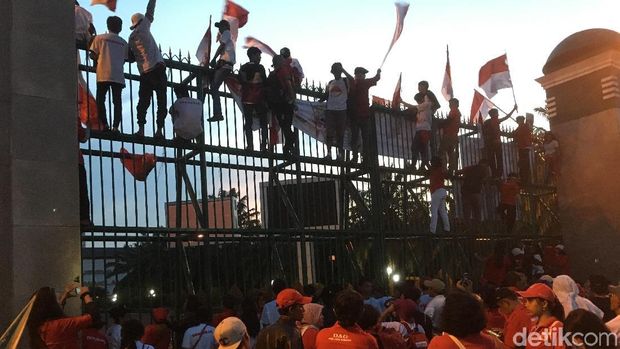 Pendemo melempar sampah dan tomat ke halaman gedung DPR, Jumat (23/3/2018)