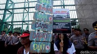 Sambil mendengarkan orasi, mereka membawa bendera merah putih, spanduk, dan papan-papan tuntutan.