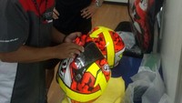 Mugi bertugas untuk menservis helm pebalap agar helm itu tetap aman dan nyaman dipakai balapan. Sehingga, pebalap tetap bisa konsentrasi tanpa terganggu oleh helm demi mendapat catatan waktu terbaik. Foto: Dok. Pribadi Mugiyono