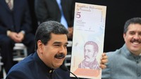 Nicolas Maduro menunjukan specimen mata uang Bbolivar yang baru. Miraflores Palace/Handout via REUTERS.