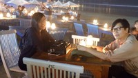 Kalau ini pose suami dan anak Dewi sedang makan malam di pinggir pantai. Romantisnya #jimbaran, tulis penyanyi yang jago nyinden ini. Foto: Instagram dewigita01