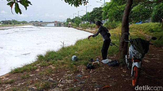 Meski dipenuhi busa di bagian permukaan, masih ada orang yang memancing di lokasi tersebut