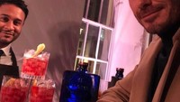 Di depan meja bar, Beckham berpose memamerkan senyumnya. Di depannya ada tiga gelas koktail yang terlihat segar. Foto: Instagram @davidbeckham