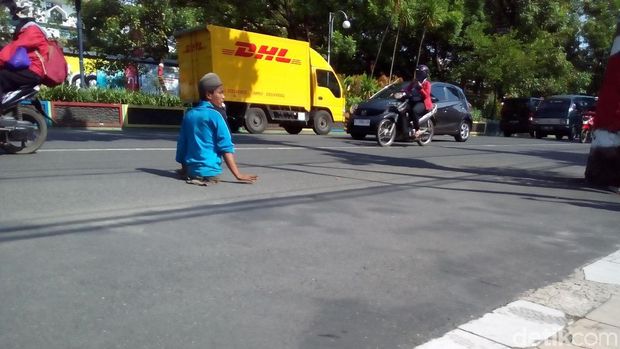 Tanpa ragu, Agus bekerja di pinggir jalan utama di Kudus. 