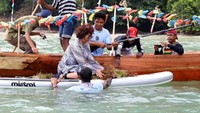 Dengan mengenakan pakaian bermotif loreng, Susi dibantu warga dalam mengumpulkan rumput laut. Pool/Humas Kementerian Kelautan dan Perikanan.
