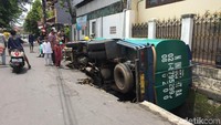Foto: Pantauan detikcom di lokasi, Minggu (25/3) sekitar pukul 11.50 WIB, truk bernomor polisi B 9224 TFU terperosok di Jl Asem Gede Utara, RT 01/05, Matraman, Jakarta Timur. Kondisi badan truk hampir seluruhnya masuk ke dalam saluran air.  (Nugroho-detikcom)