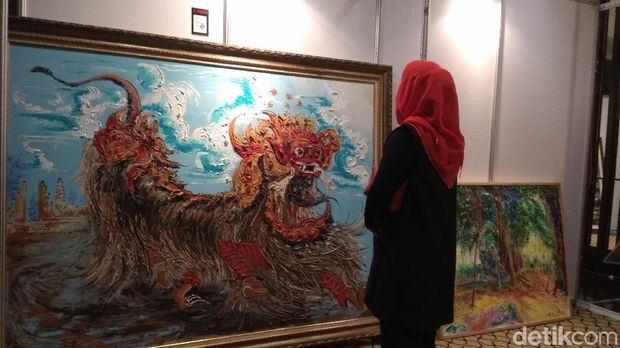 Puti memandangi lukisan barong