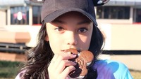 Mampir ke Walt Disney World, Naura mencicip ice cream sandwich Mickey. Meski wajahnya silau terkena cahaya, Naura tetap kelihatan cantik. Foto: Instagram aku_naura