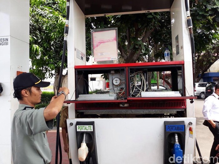 Petugas Direktorat Metrologi Kementerian Perdagangan dan Metrologi DKI Jakarta mengecek nozzle dan mesin pengisi bahan bakar di SPBU Pertamina yang viral di Condet, Senin (26/3/2018)