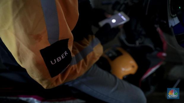 Driver Uber melintas di kawasan Arteri Jakarta Selatan, Senin (26/3). Grab resmi mengakuisisi seluruh bisnis Uber di Asia Tenggara. Manajemen mengklaim merger ini akan dapat meningkatkan inklusifitas dan kemudahan akses. (CNBC Indonesia/Muhammad Sabki)