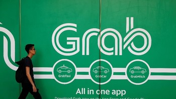 Seorang pria berjalan di depan kantor Grab di Singapura. Ke depannya, pihak Grab akan segera melakukan migrasi mitra pengemudi, merchant, hingga pelanggan dari layanan berbagi tumpangan dan pemesanan milik Uber ke dalam platform milik mereka. Foto: Reuters